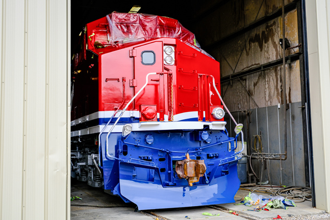 A partially completed locomotive peeks out from the shop. 