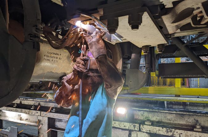 A machinist at our Topeka shop attaches the prototype ODIN to a locomotive for testing.  A machinist at our Topeka shop attaches the prototype ODIN to a locomotive for testing.